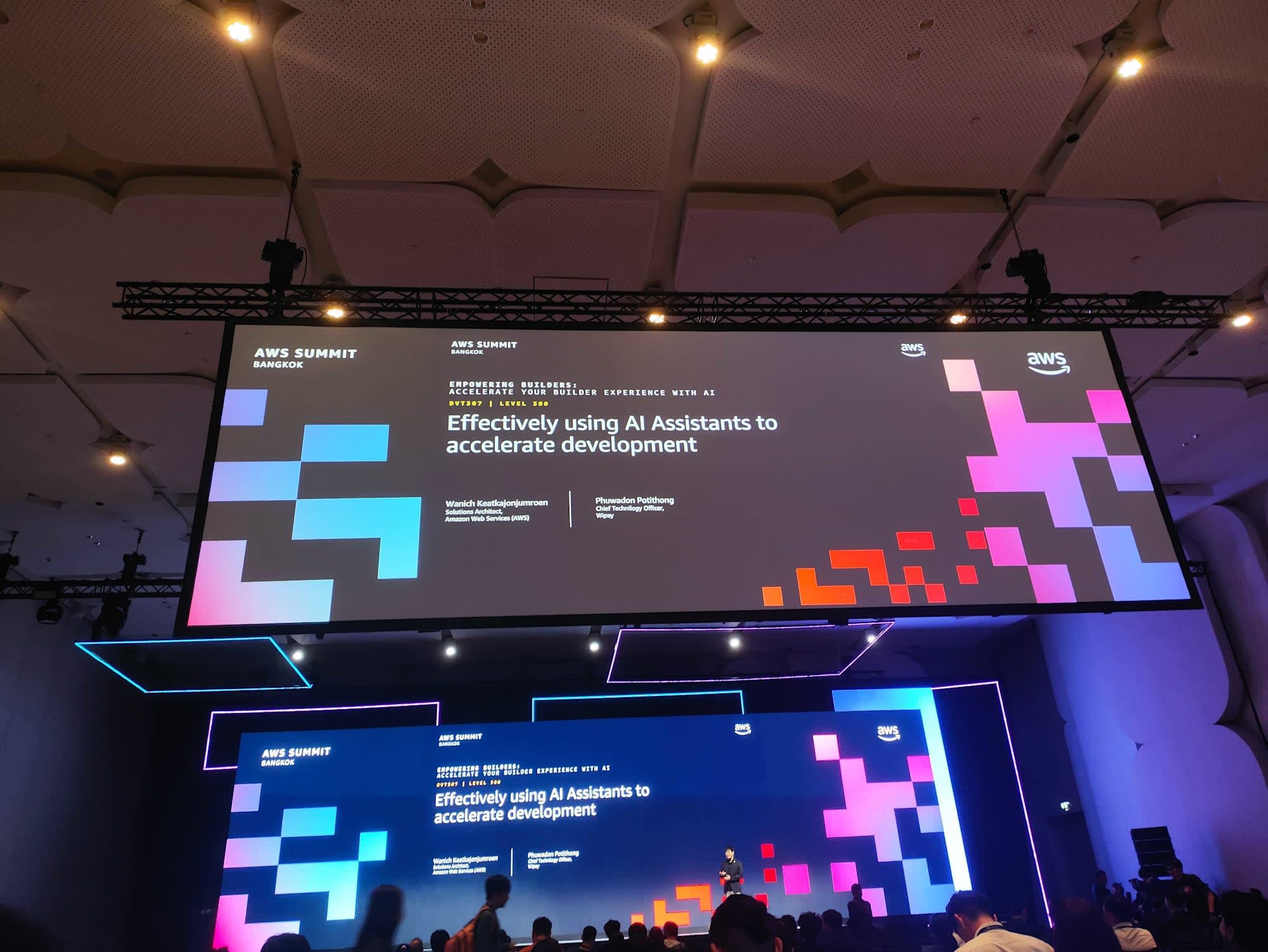 สไลด์เปิด session DVT307 "Effectively using AI Assistants to accelerate development" พร้อมชื่อสปีกเกอร์จาก AWS และ Wipay