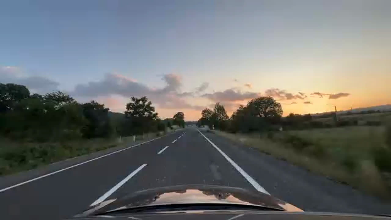 similar_other_environment の代表: 夕暮れの空き道を車が走行する 1 フレーム